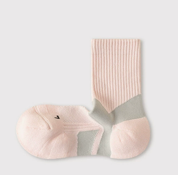 Athletic crew socks in pink and white, featuring cushioned zones and arch bands. Shown as a flat-lay pair.