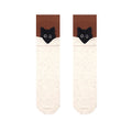 Black cat socks in ivory with a black cat peeking over a brown cuff, flat-lay pair.
