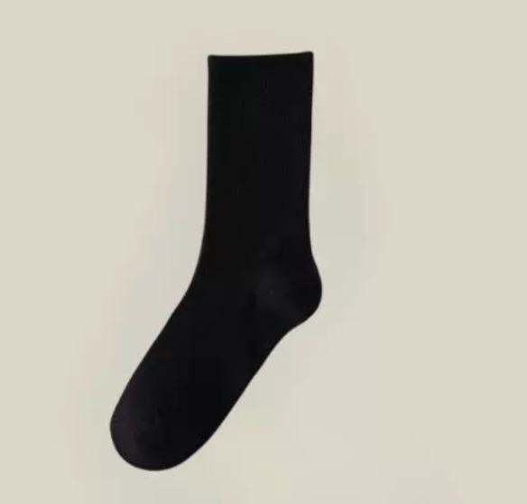 Black crew socks in ribbed cotton, featuring a smooth crew length. Shown as a single flat-lay on a neutral backdrop.