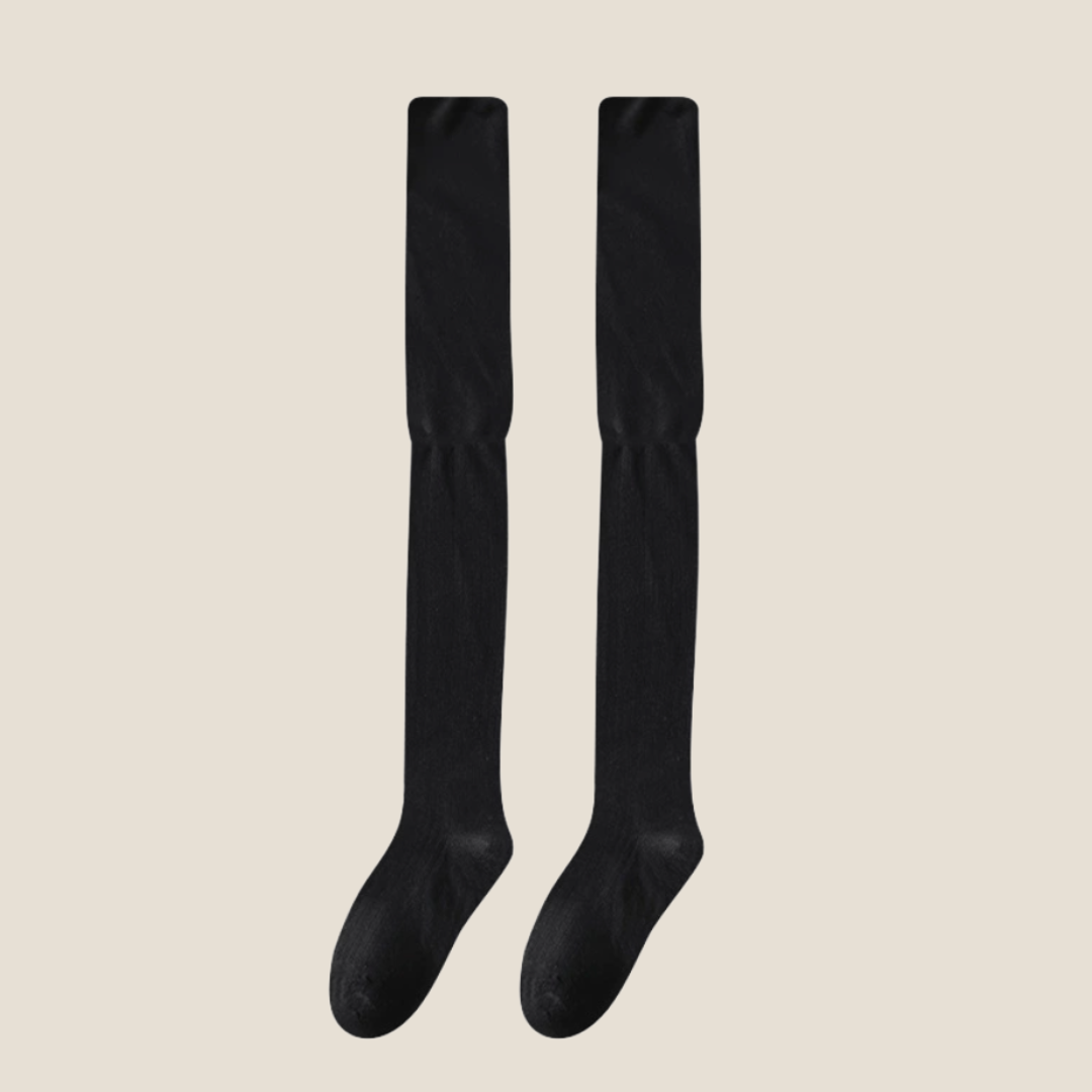 Black over the knee socks in solid black ribbed knit, featuring a tall stretchy leg. Shown as an upright flat-lay pair.