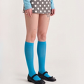 Blue fashion knee socks in bright blue sheer knit, featuring a smooth leg. Worn with a polka-dot skirt.