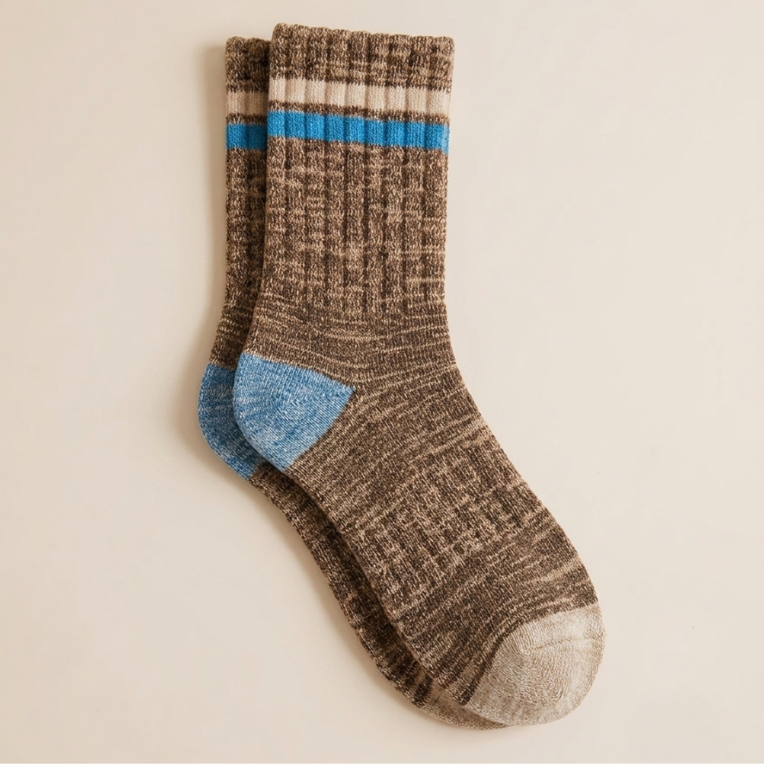 Boot socks for women in brown marled knit, featuring a blue stripe and heel accent. Displayed flat on a warm surface.
