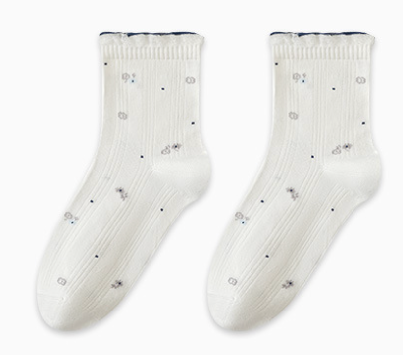 Breathable socks for sleeping in ivory cotton, featuring a scattered dot pattern and frilled cuff. Shown flat as a pair on a neutral surface.