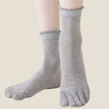 Breathable toe socks in light grey knit, featuring a ruffle cuff and airy weave. Worn on the feet to show the toe design.