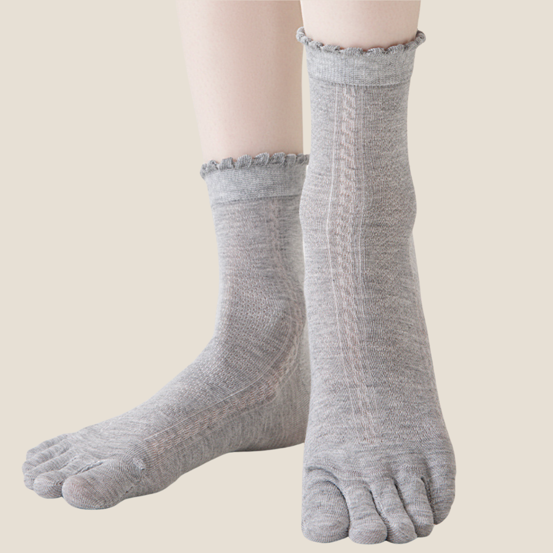 Breathable toe socks in light grey knit, featuring a ruffle cuff and airy weave. Worn on the feet to show the toe design.