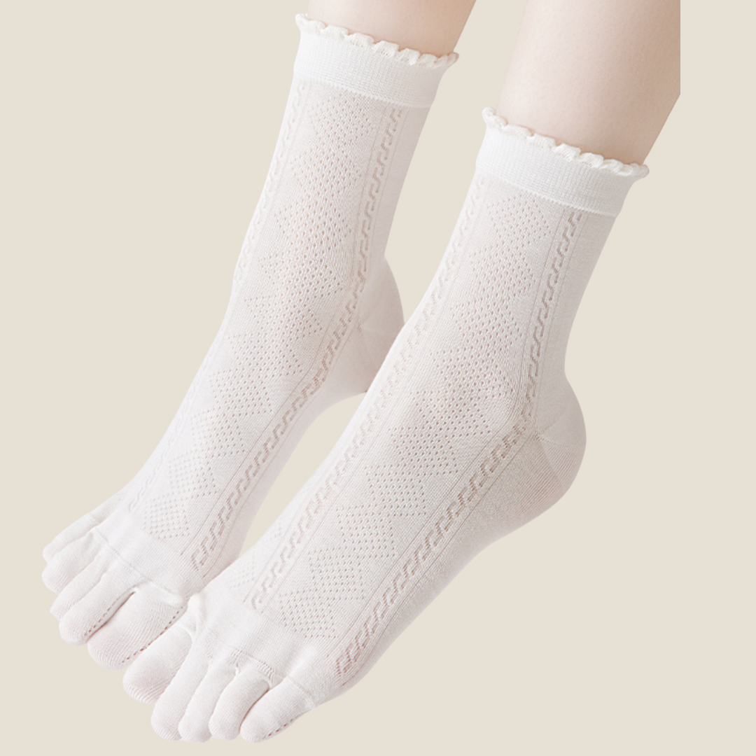 Breathable toe socks in white cotton, featuring a scalloped ruffle cuff. Worn on the feet in a soft setting.