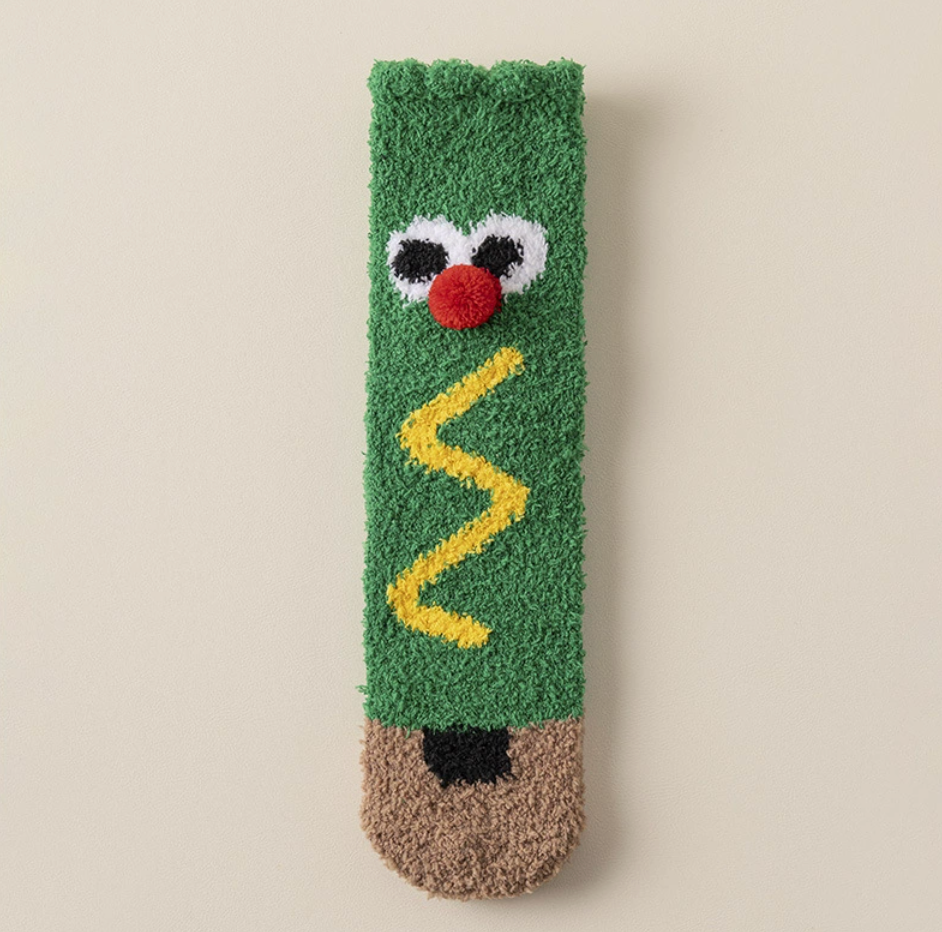 Bulk Christmas socks, a single green plush Christmas-tree pair with a cartoon face.