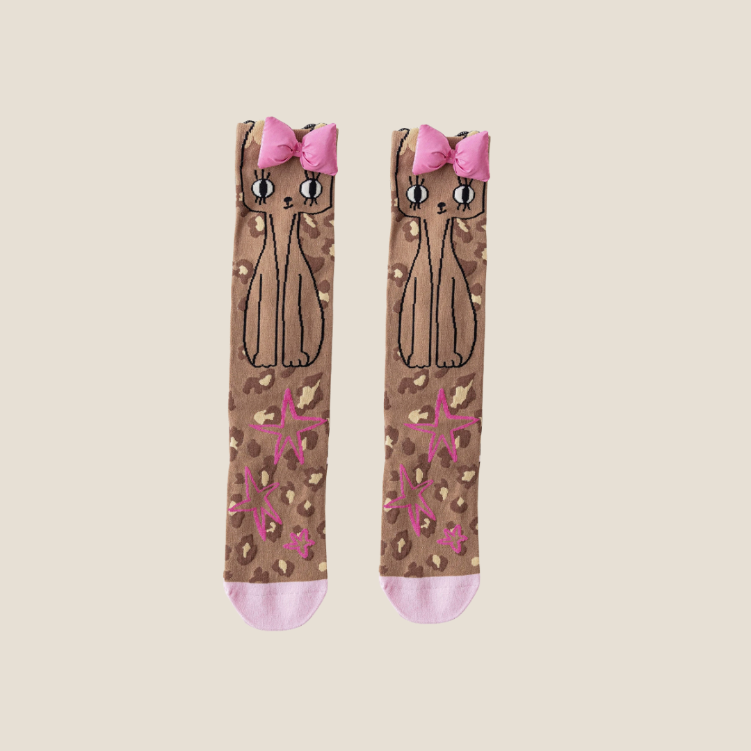 Cat knee socks in brown cartoon cat print, featuring pink bow accents. Shown as an upright flat-lay pair.