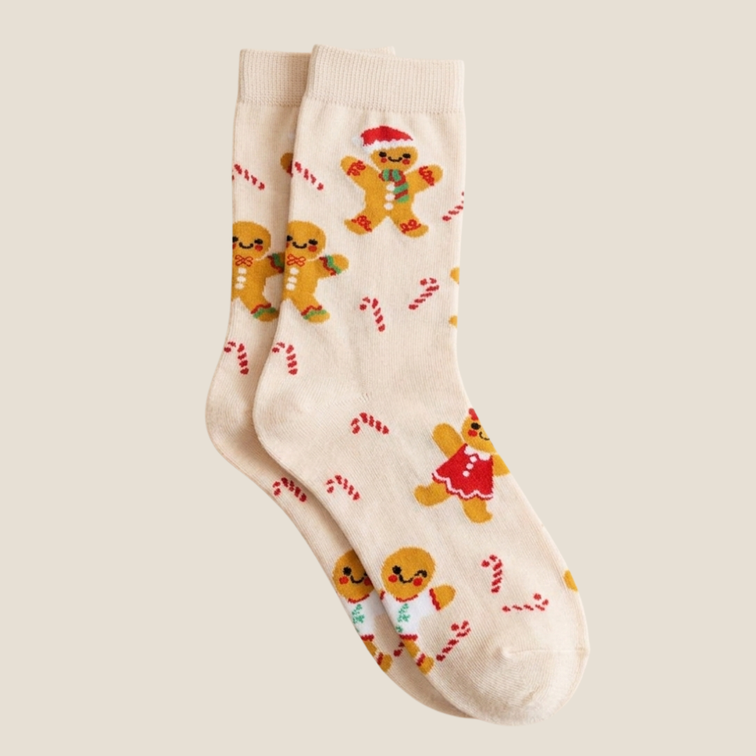 Gingerbread Christmas socks in beige with gingerbread and candy-cane prints, worn on the legs.