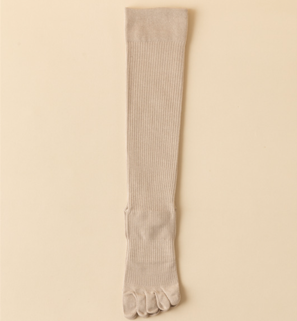 Compression toe socks in ivory ribbed knit, featuring a tall knee-high leg. Shown as a single flat-lay on a light surface.