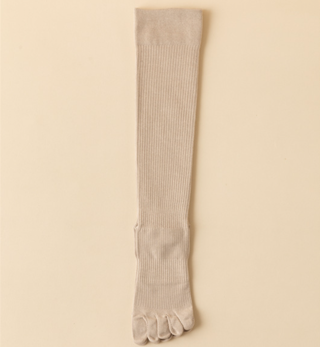 Compression toe socks in ivory ribbed knit, featuring a tall knee-high leg. Shown as a single flat-lay on a light surface.