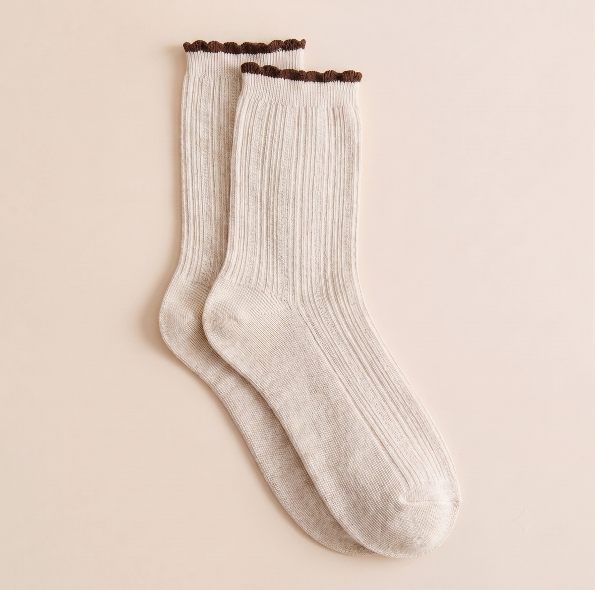 Cotton boot socks in cream, featuring a ribbed body with a black frilled cuff. Displayed flat as a pair on a neutral surface.
