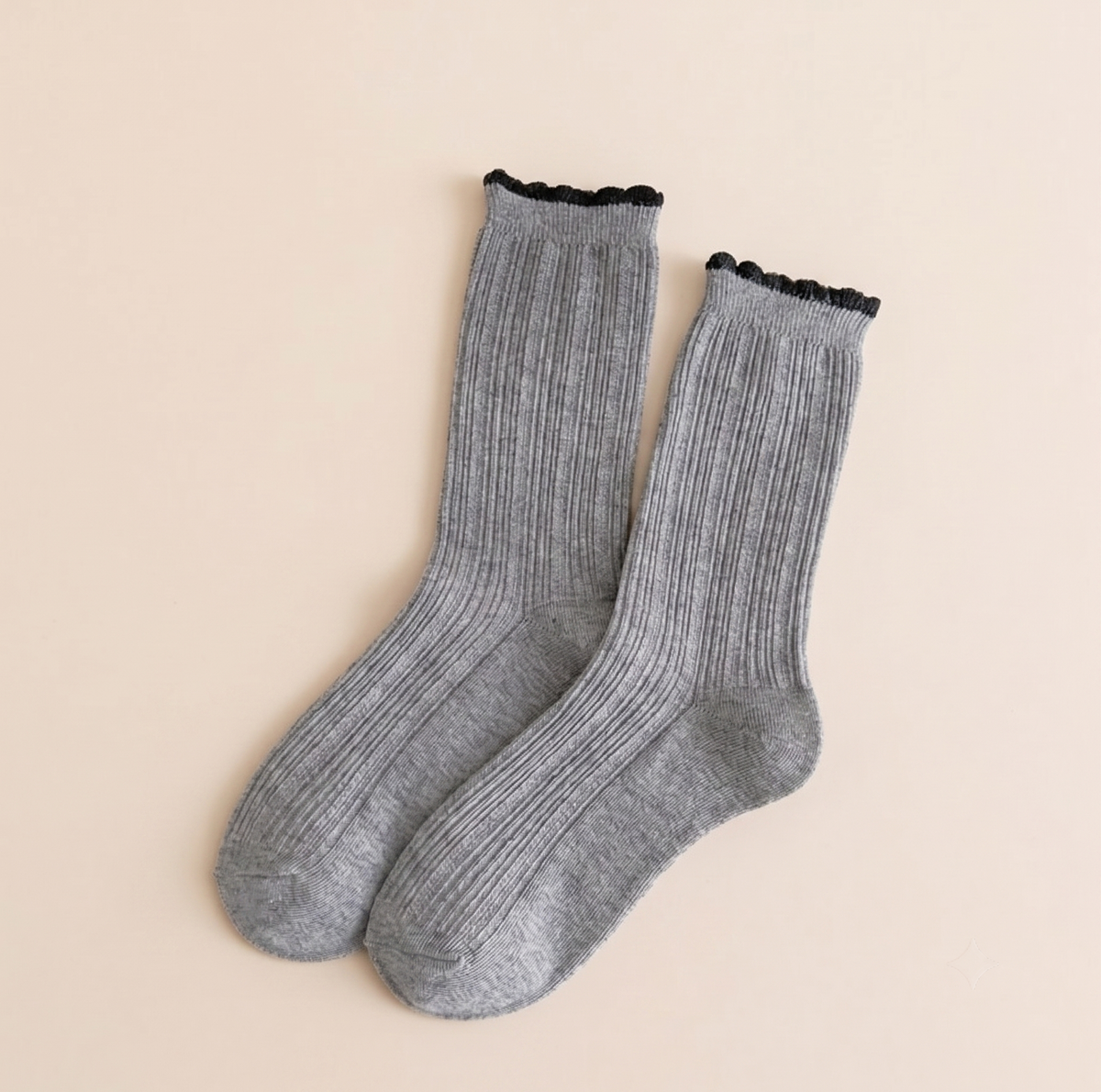 Cotton boot socks in grey, featuring a ribbed knit with a black ruffle-trim cuff. Shown as a flat-lay pair on a light backdrop.