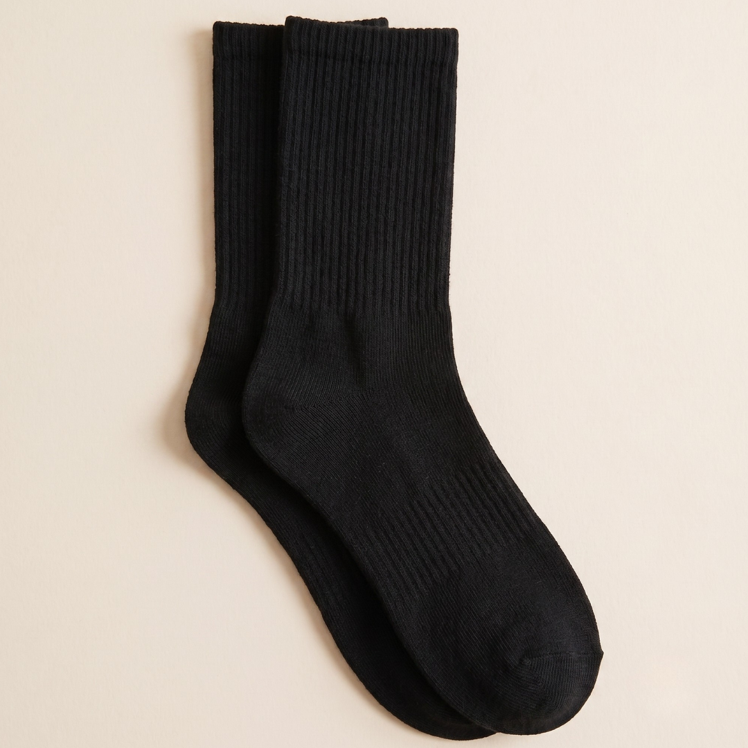 Cotton crew socks in black ribbed cotton, featuring a soft crew length. Shown as a single flat-lay on a neutral backdrop.