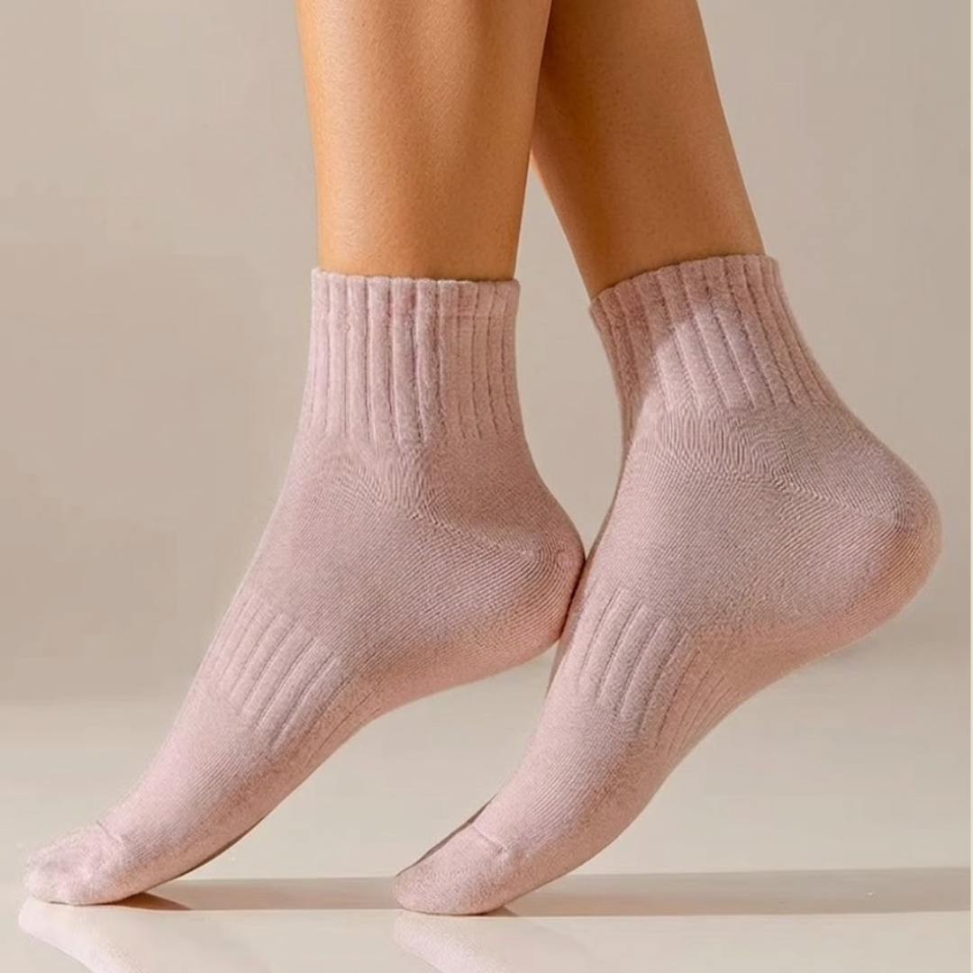 Cotton quarter socks in soft pink, featuring a breathable ribbed knit. Worn on feet and lower legs.