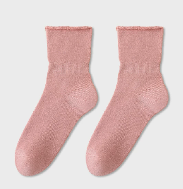 Cotton sleep socks in rose pink, featuring a fine ribbed texture. Displayed as a flat-lay pair on a neutral surface.