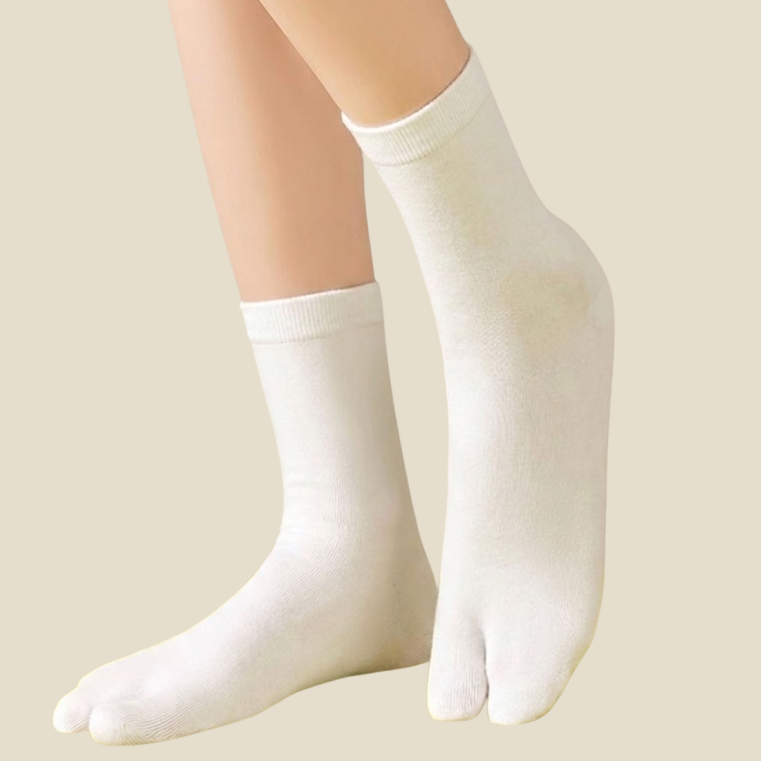 Cotton tabi socks in white, featuring a soft split-toe cotton knit. Worn on feet to show the divided toe.