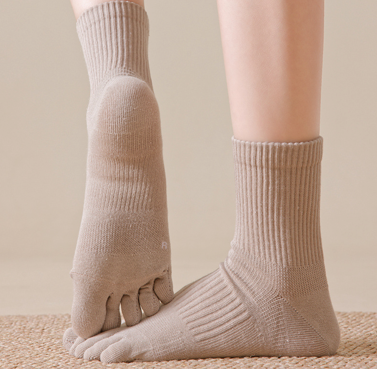 Cotton toe socks in tan ribbed cotton, featuring individual toe pockets. Worn on one foot to show the fit.