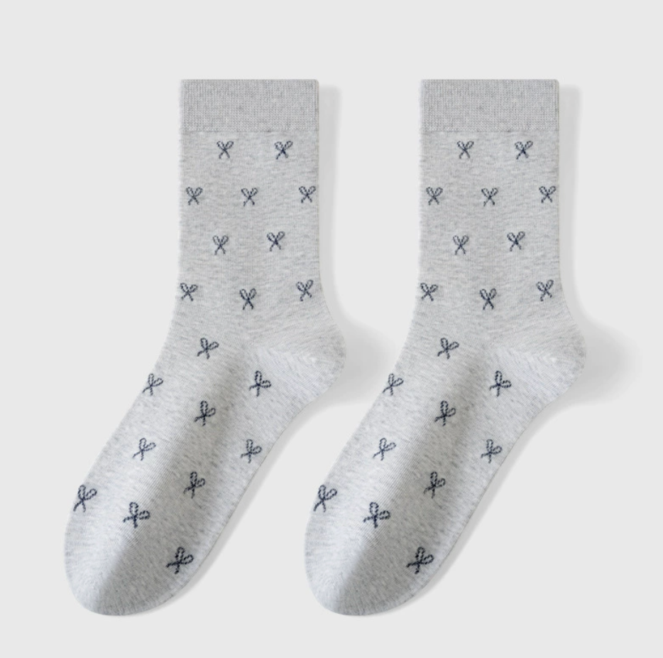 Cozy crew socks in white and grey with a small bow pattern, featuring a plush texture. Displayed flat as a pair on a light surface.