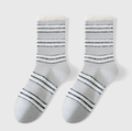 Cozy crew socks in white and grey with dark stripes, featuring a soft knit. Shown as a flat-lay pair on a neutral backdrop.