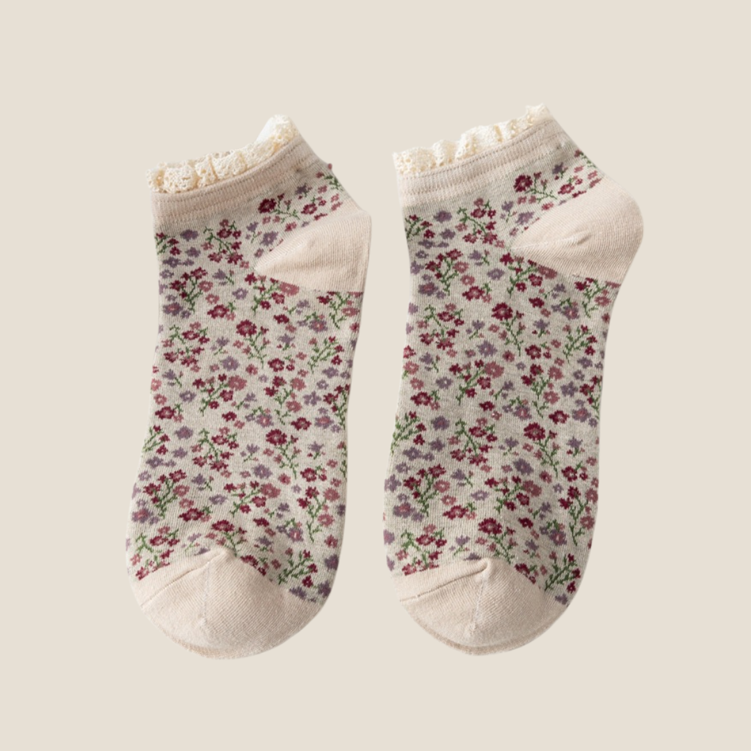Cute ankle socks in cream with a floral print and lace ruffle trim, flat-lay pair.