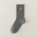 Cute crew socks in grey knit, featuring a bow embroidery. Shown as a single flat-lay on a light surface.