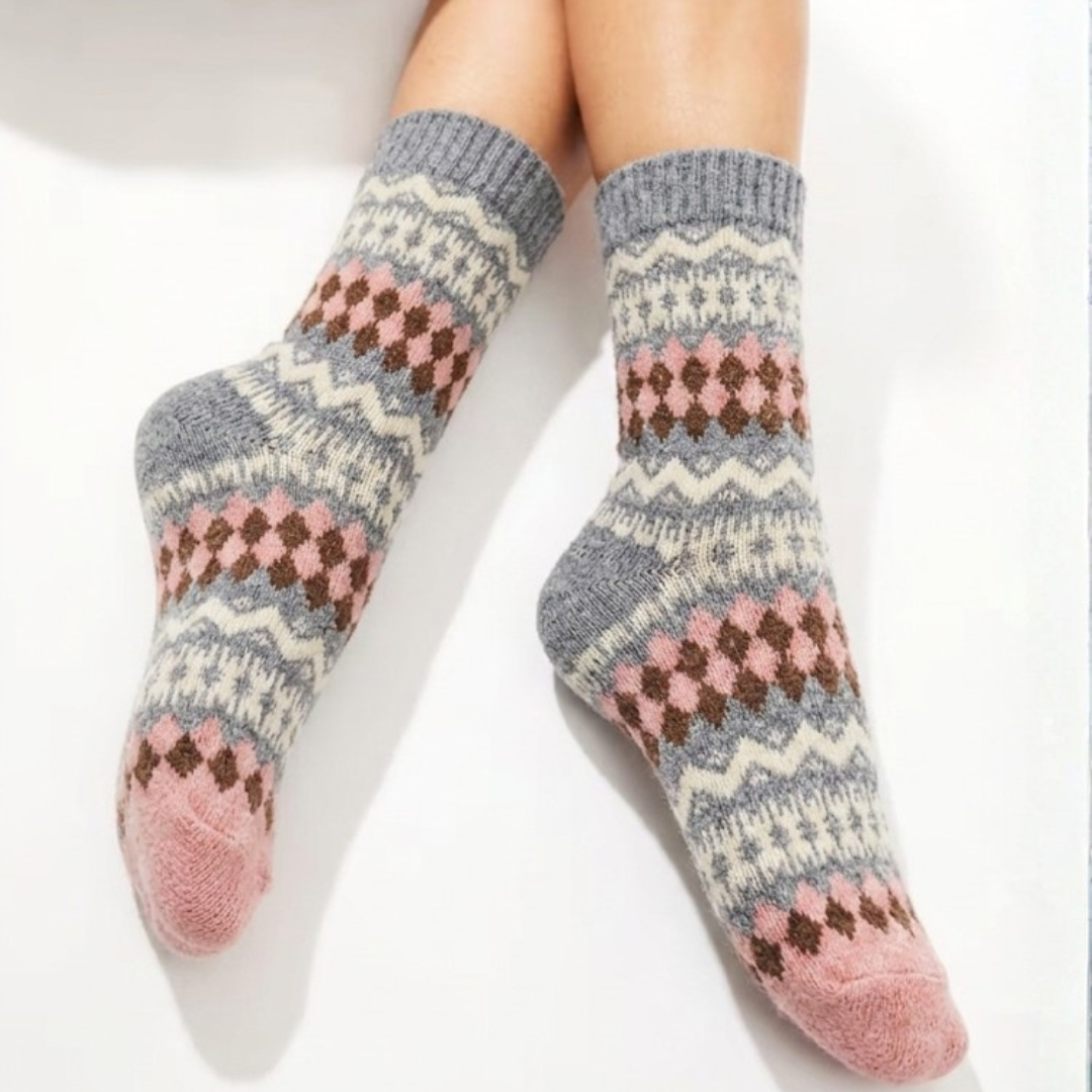 Cute fair isle socks in pink and gray Nordic knit, worn on the feet, front view.