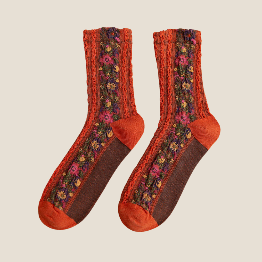 Cute floral socks in rust orange with embroidered flowers and a contrasting orange toe, flat-lay pair.