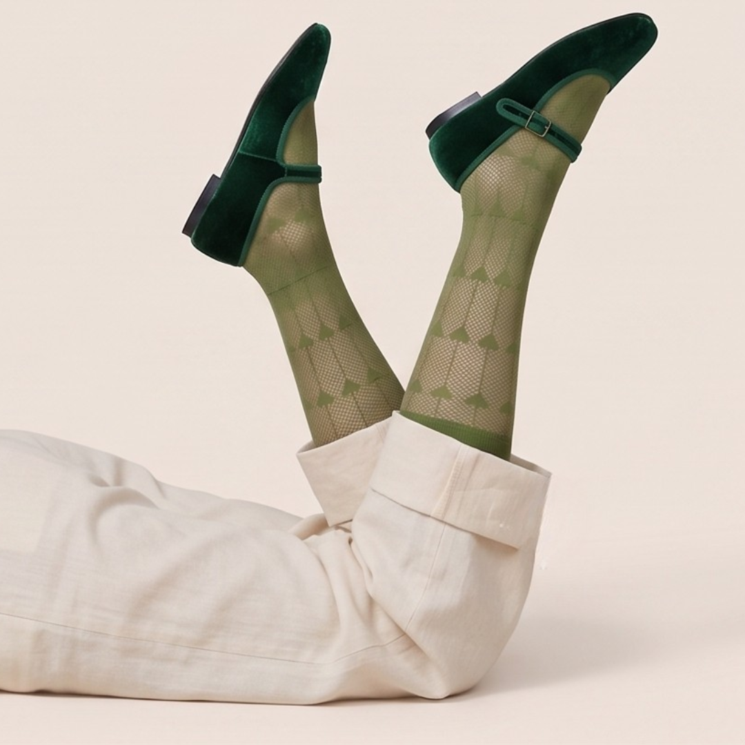 Cute knee high socks in olive green sheer knit, featuring a fine texture. Shown in a playful legs-up pose.