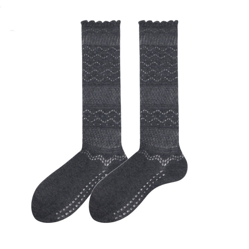 Cute knee high stockings in gray pointelle knit, flat-lay pair with a scalloped cuff.