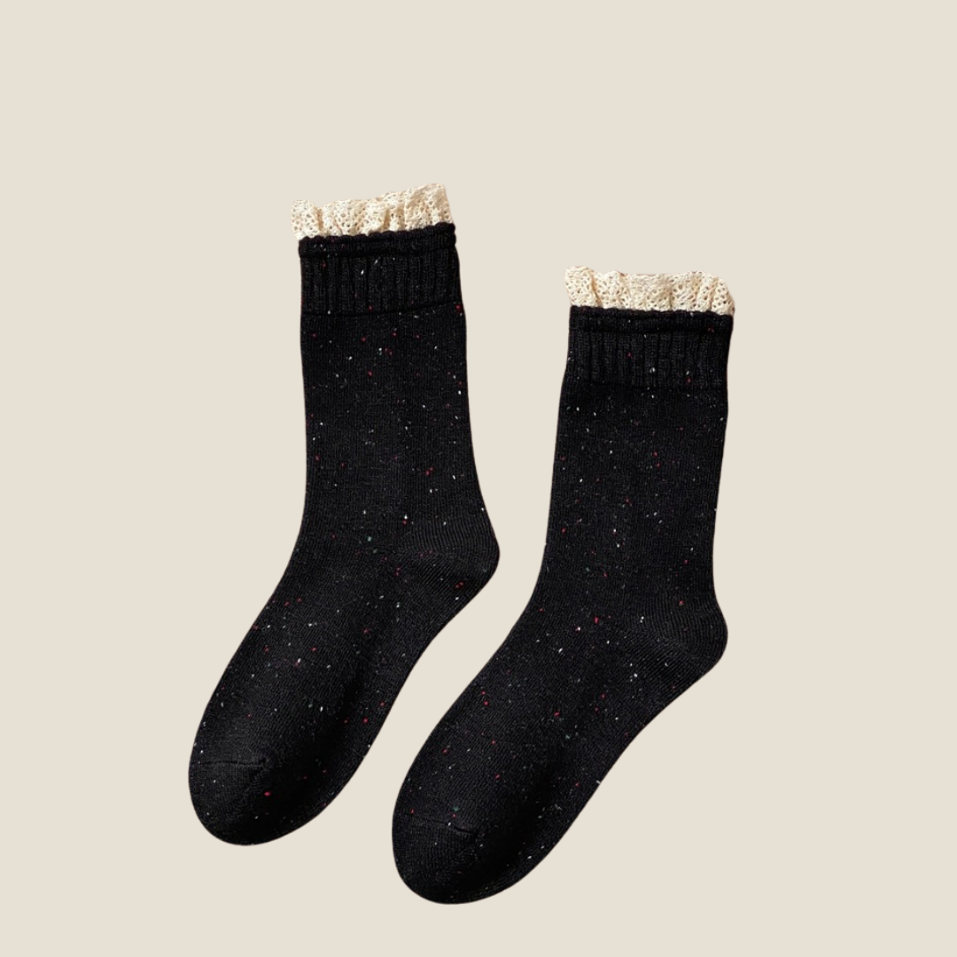 Cute lace socks in black marled knit with a lace ruffle cuff, flat-lay pair.