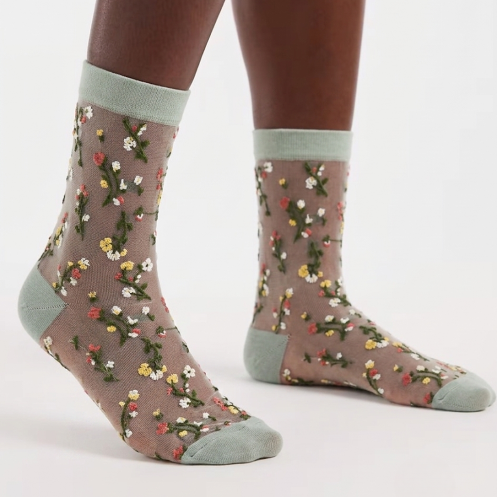 Cute sheer socks in floral mesh with a soft green cuff and toe, worn on the feet.