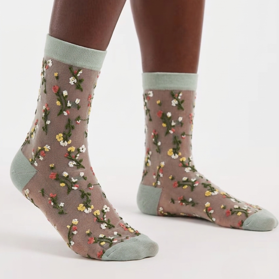 Cute sheer socks in floral mesh with a soft green cuff and toe, worn on the feet.