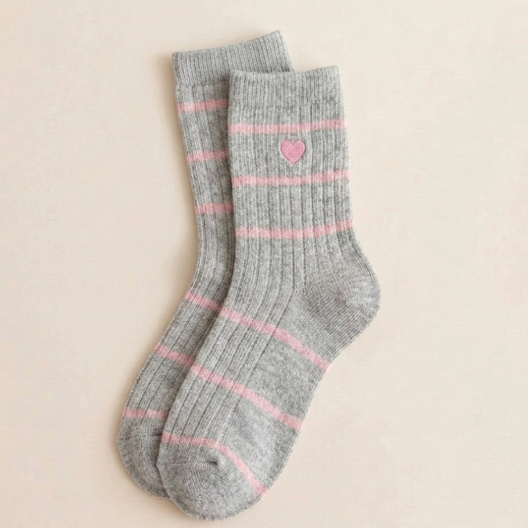 Cute winter socks for women in gray ribbed knit with a pink stripe and heart detail, flat-lay pair.