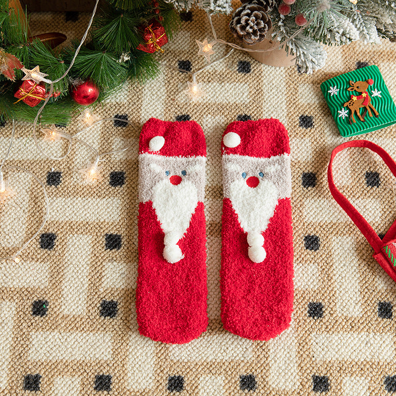 Cutest Christmas socks in red plush with a Santa design, flat-lay pair styled with pinecones and gifts.