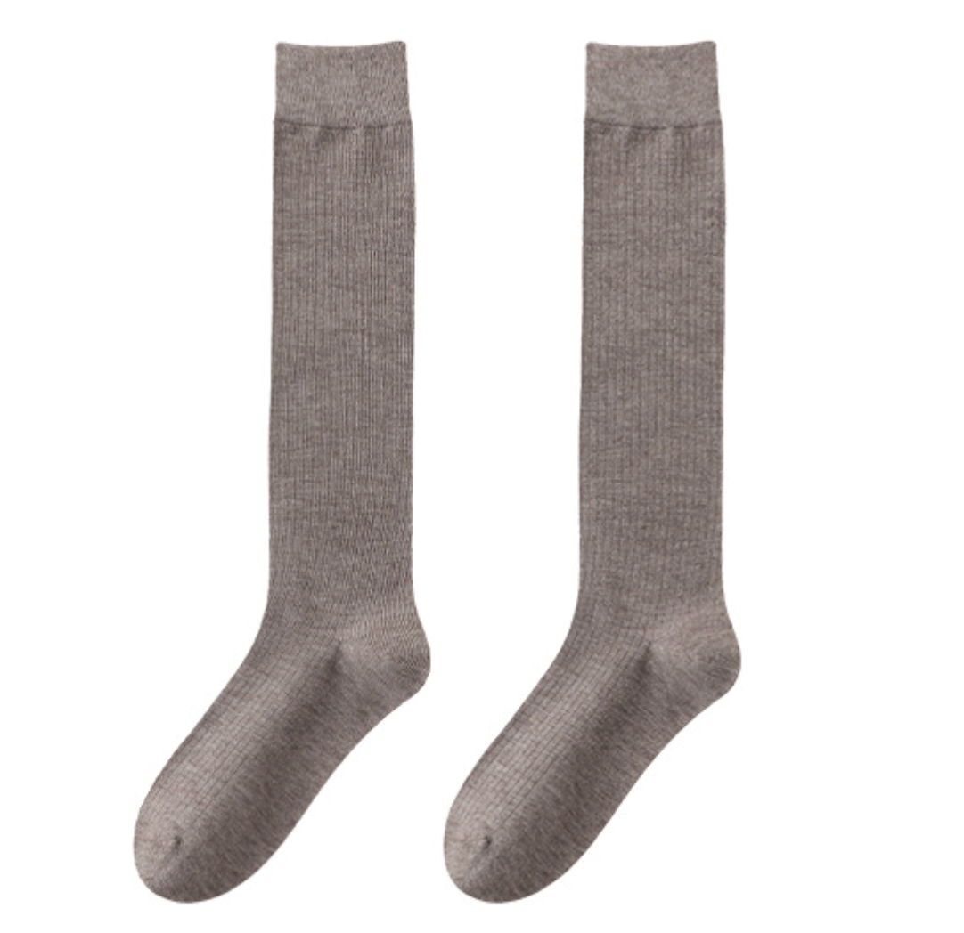 Dress socks for loafers in light khaki-gray ribbed knit, a flat-lay pair on a white background.