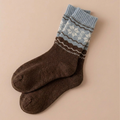 Fair isle Christmas socks in coffee brown wool with a blue-and-cream Nordic band, flat-lay pair.