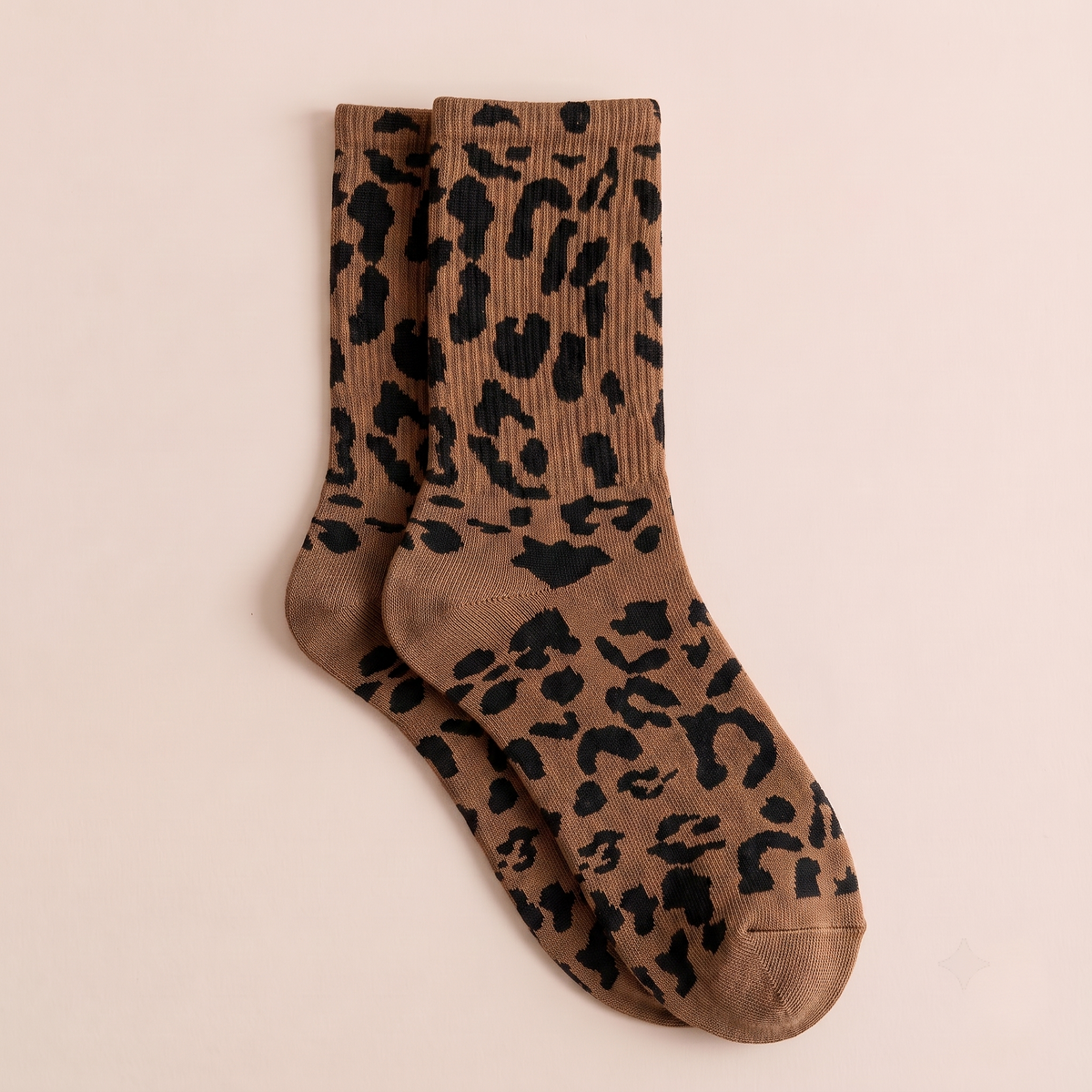 Fashion boot socks in brown and tan, featuring a leopard-print jacquard. Shown as a flat-lay pair on a warm surface.
