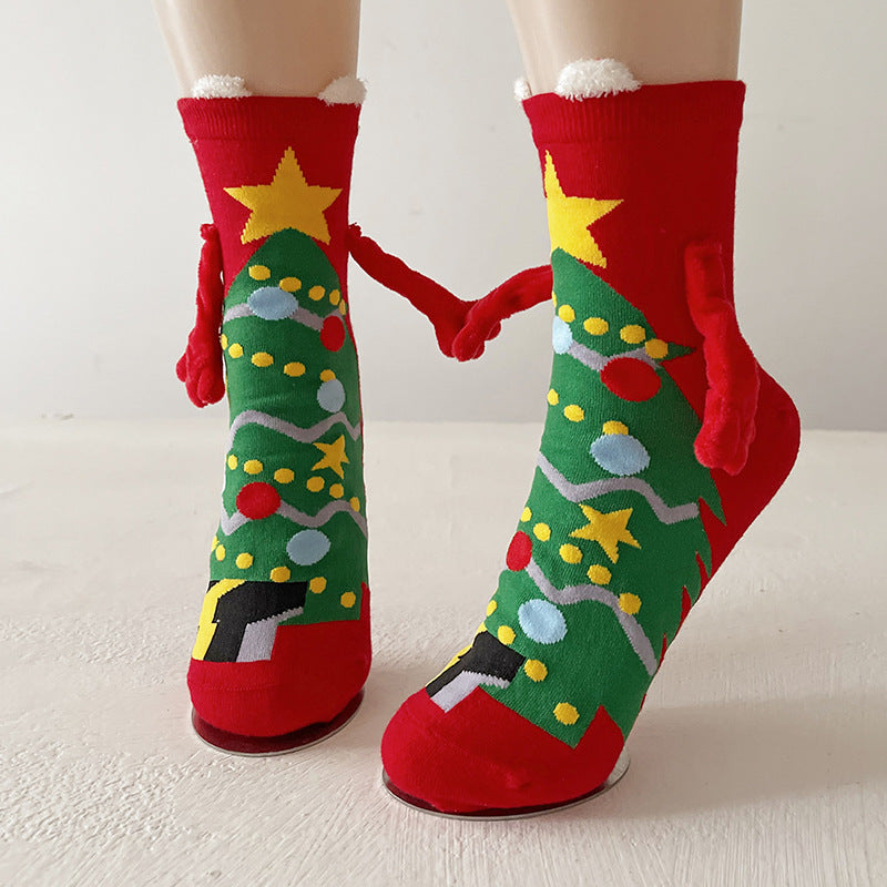Funny Christmas socks in green with a Christmas-tree design and magnetic hands, holding hands between two feet.