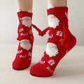 Funny Christmas socks in red with a Santa print and magnetic hands, shown holding hands on the feet.