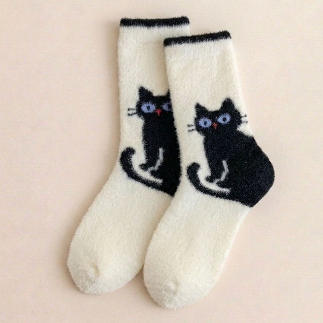 Fuzzy cat socks in white plush fleece with a black cat silhouette, flat-lay pair.