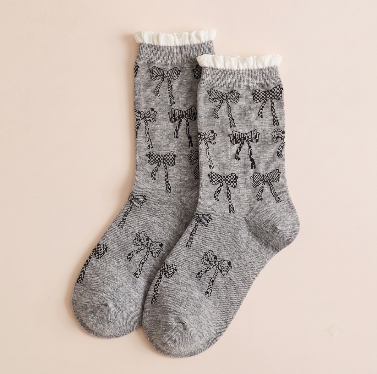 Girls' boot socks in grey, featuring a bow pattern with a lace-trim cuff. Displayed flat as a pair on a neutral backdrop.