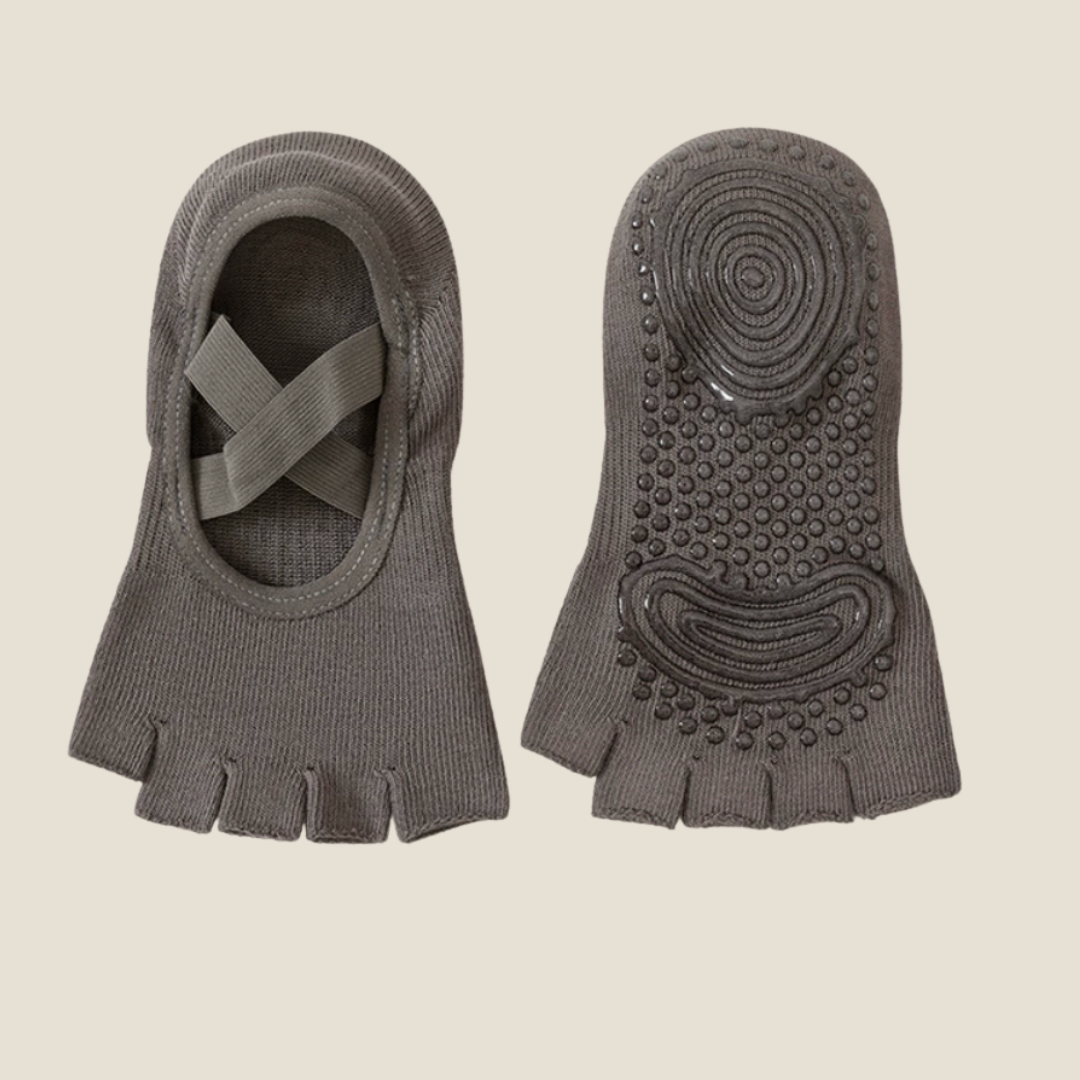 Half toe socks in charcoal grey, featuring a cross-strap top and non-slip grip sole. Shown as a pair to display the pilates design.