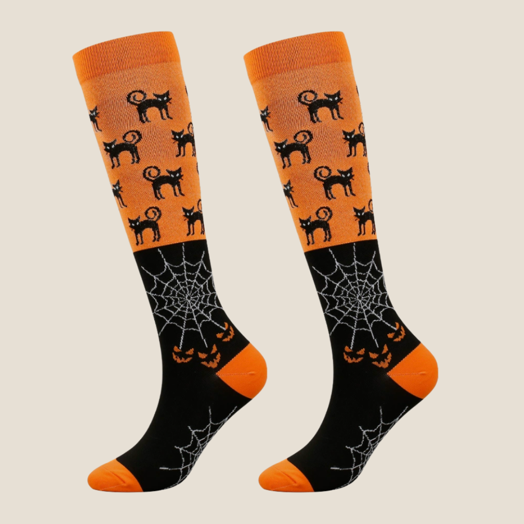 Halloween knee socks in orange with black cats and spiderwebs, featuring a festive print. Shown as an upright flat-lay pair.