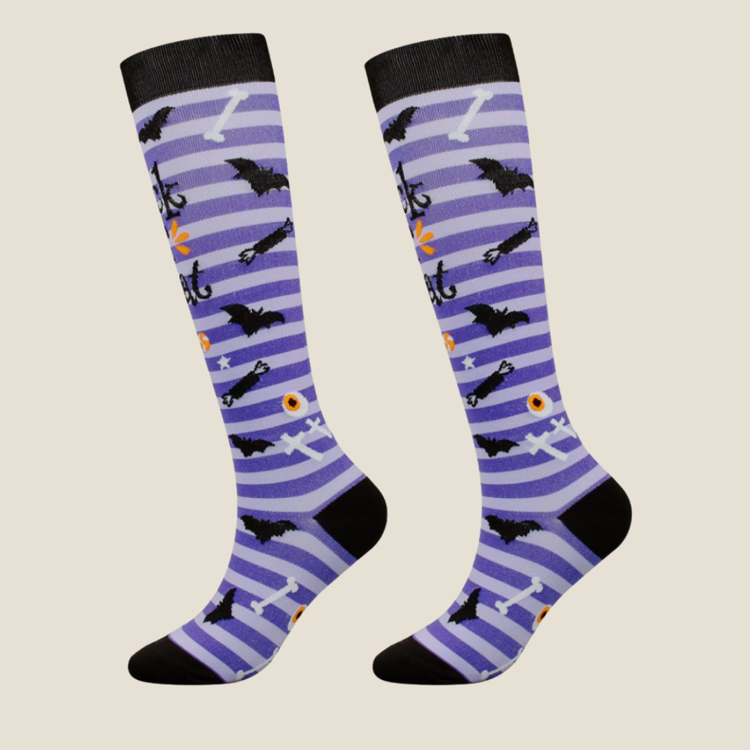 Halloween knee socks in purple with black cats and bats, featuring a spooky pattern. Worn on legs for a costume look.