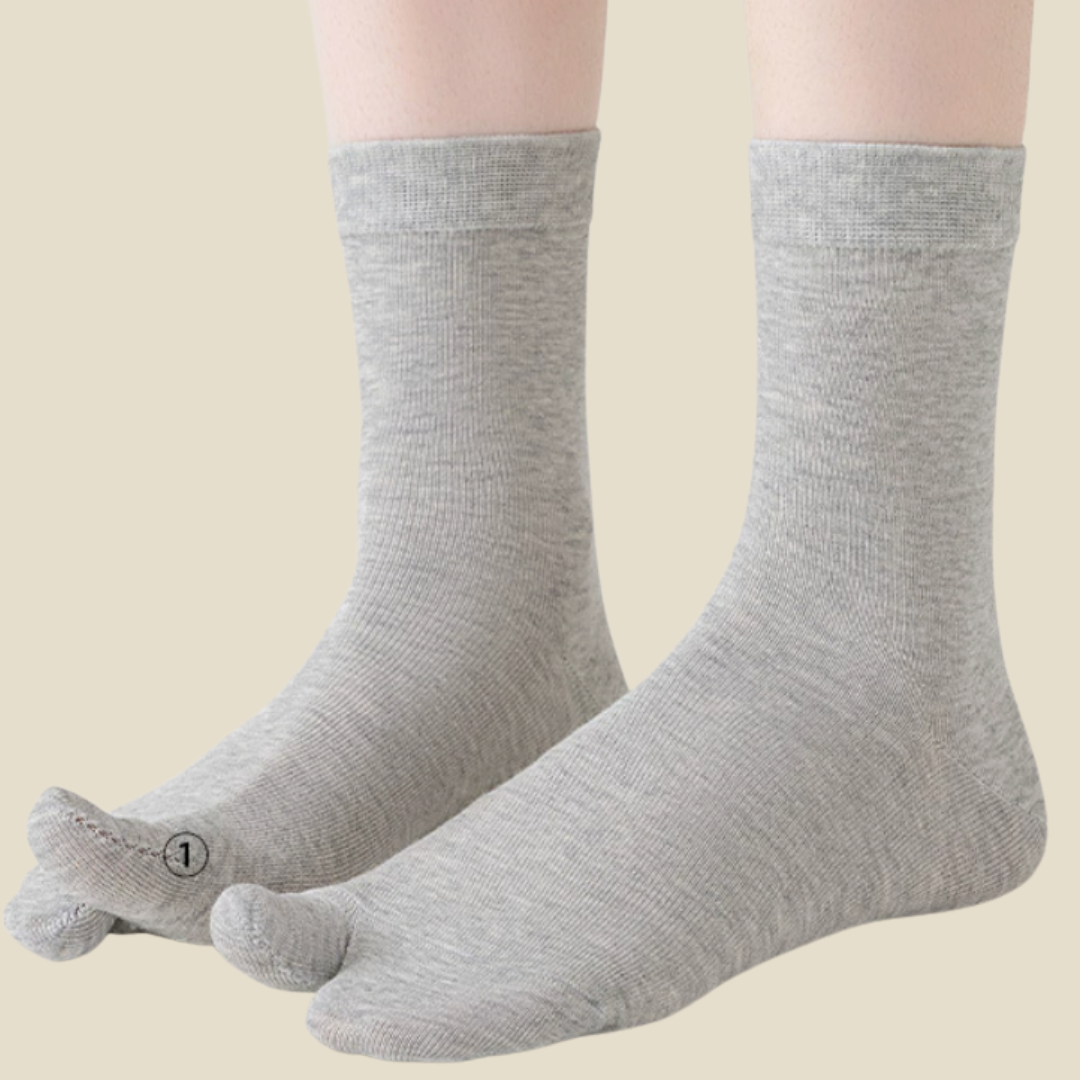 Japanese tabi socks in grey, featuring a split-toe cotton knit. Worn on feet in a styled setting.