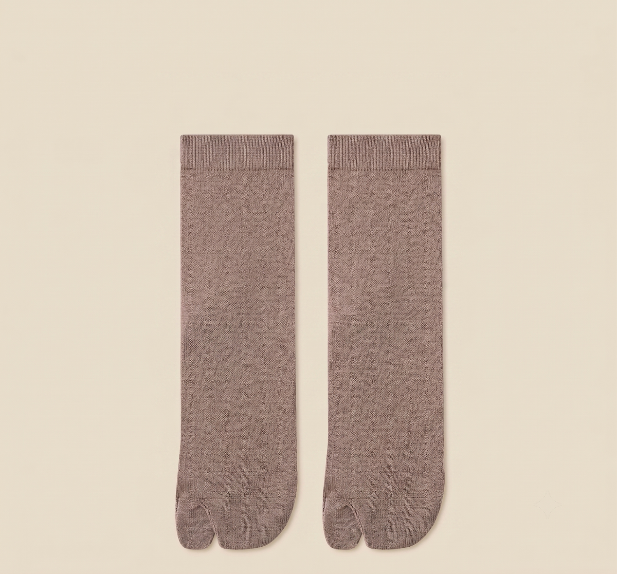 Japanese tabi socks in taupe, featuring a divided-toe design. Shown as a flat-lay pair on a neutral backdrop.