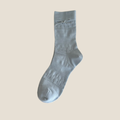 Kawaii socks for women in light blue mesh with a bow, single sock shown flat.