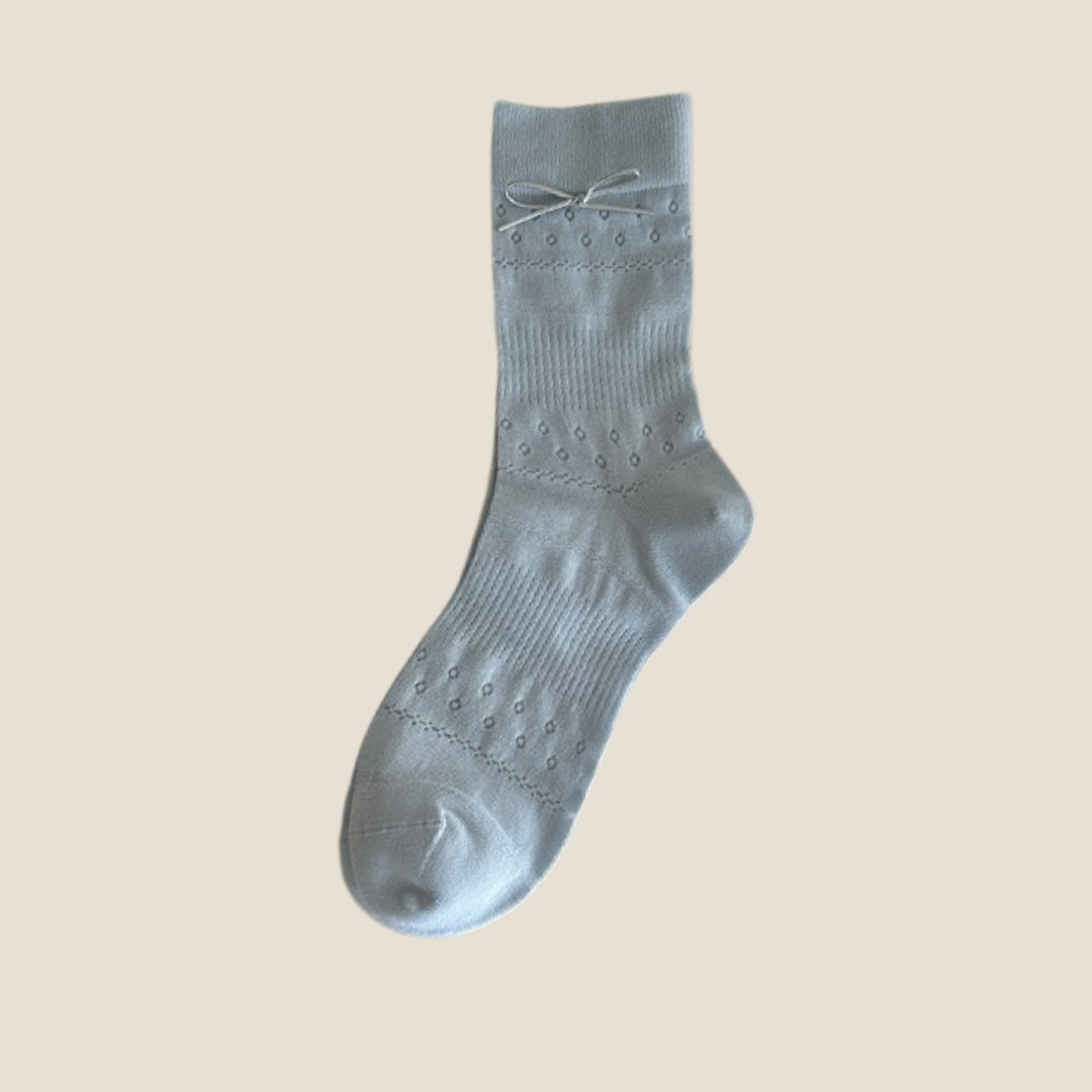 Kawaii socks for women in light blue mesh with a bow, single sock shown flat.