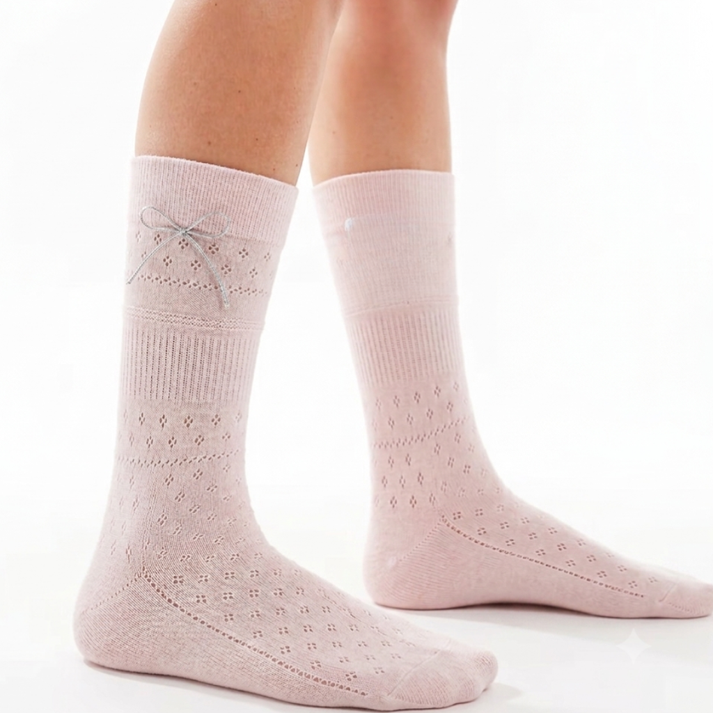 Kawaii socks for women in soft pink with a tiny bow, worn on the legs, front view.